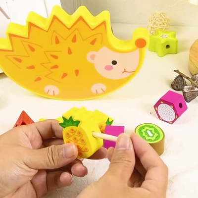 木の積み重ねはフルーツがバランスのゲームのMontessoriのおもちゃを妨げるブロックのおもちゃの漫画の動物のハリネズミのバランスをとる